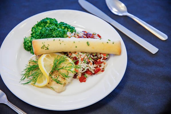 A plated meal featuring fish, rice, and broccoli