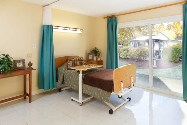 A resident's room with a bed and view of an outdoor space