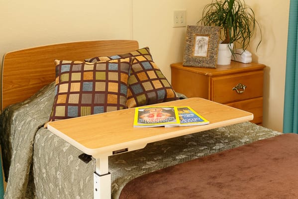 Cozy resident room with bedside table and pillows