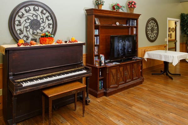 Interior view of a common area with a piano and furniture