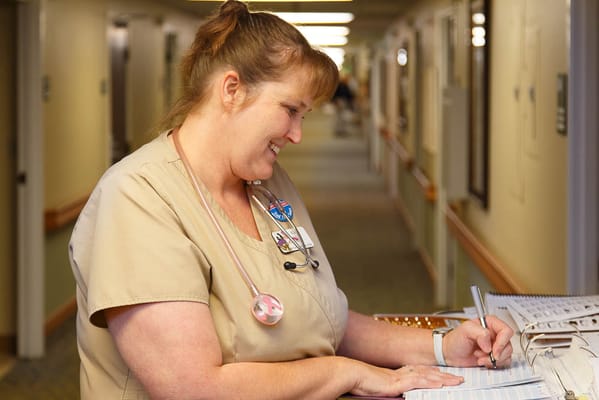 Staff member writing in a hallway
