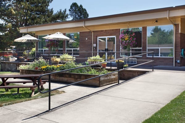 Outdoor area with a ramp, gardens, and patio seating