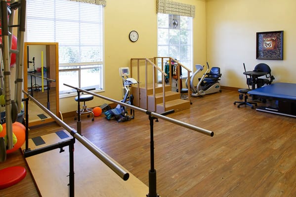 Rehabilitation room with therapy equipment and training bars