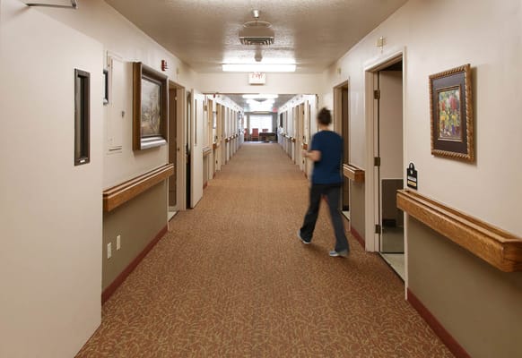 A hallway in the assisted living facility with a staff member walking