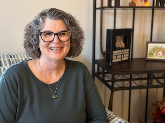 A smiling resident in a cozy living area