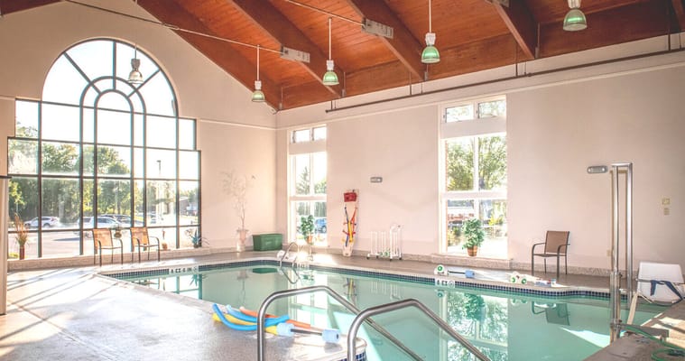 Indoor pool area with large windows and seating
