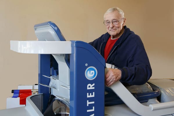 Elderly man using rehabilitation equipment in a bright room