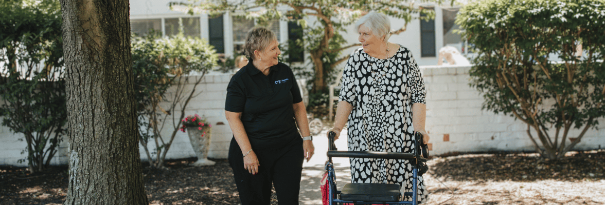 Care staff assisting a resident outdoors