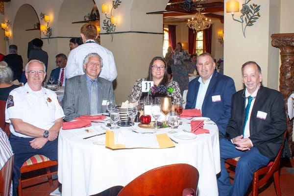 A group of people sitting around a dining table at an event