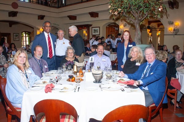 Residents and staff enjoying a meal together at a dining table