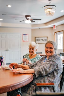 Two smiling residents enjoying time together at a table