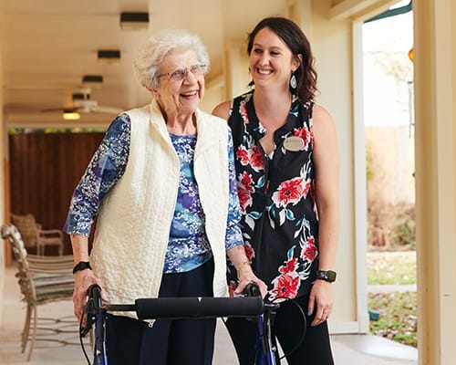 Staff assisting a resident in a hallway
