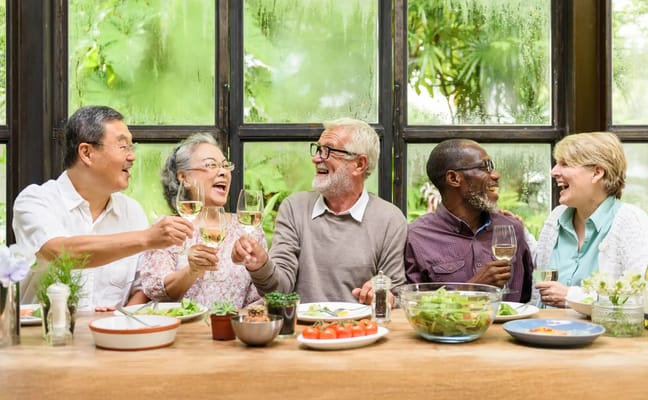 A group of seniors enjoying a meal and toasting together