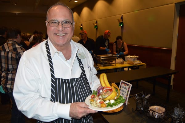 Staff member presenting a gourmet meal at an event