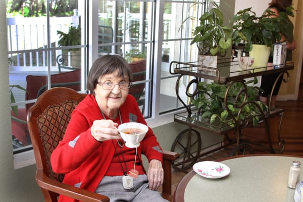 A resident enjoying tea in a cozy interior space