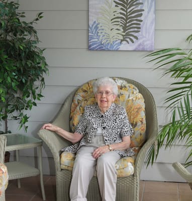 Senior resident relaxing in armchair in a lounge area