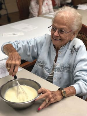 Senior resident mixing ingredients in a bowl