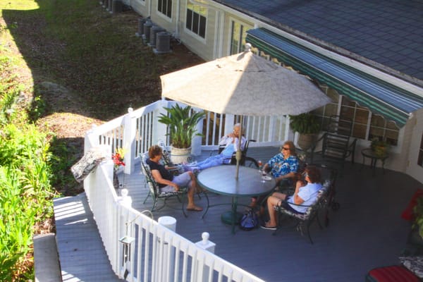 Residents enjoying social time on a sunny outdoor patio