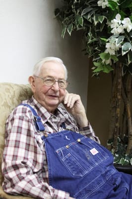 Senior man smiling while sitting in a cozy chair