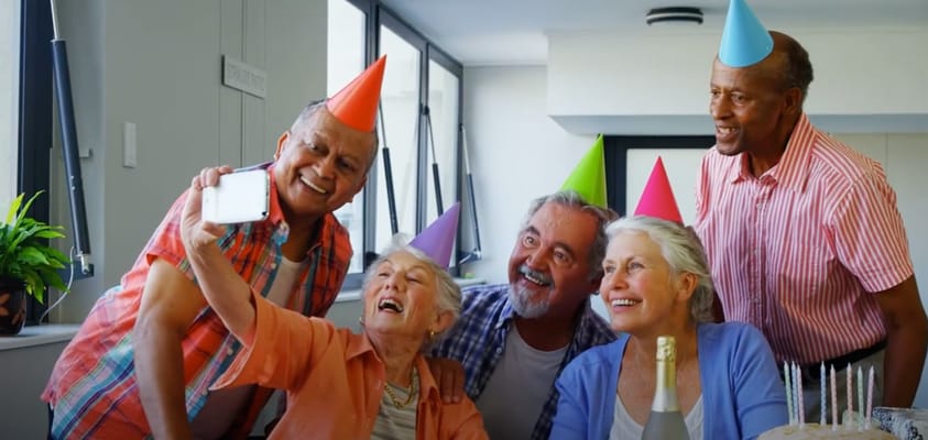Residents celebrating with party hats and a cake