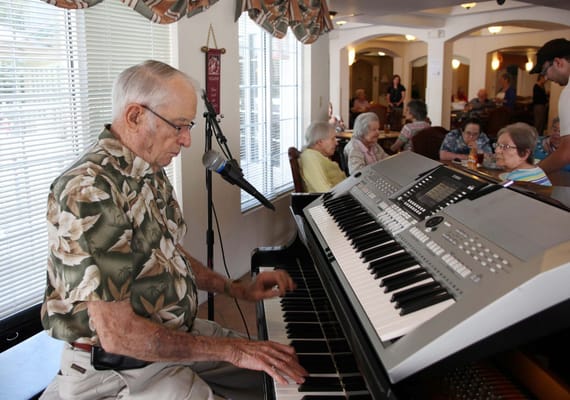 Resident playing piano in a common area