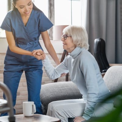Staff assisting a resident in a cozy living room