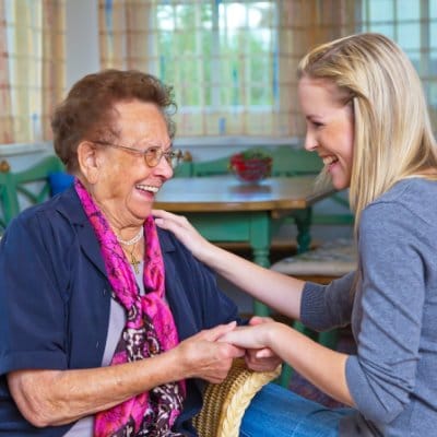 A resident and staff member sharing a joyful moment