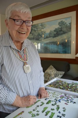 Resident engaged in a puzzle activity with a smile