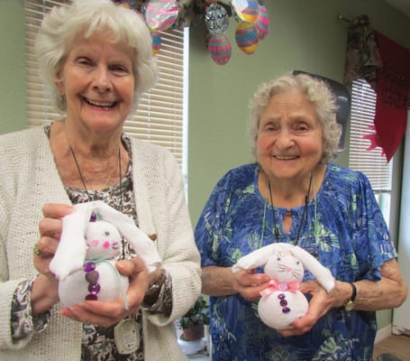 Two residents making craft snowmen in a common area