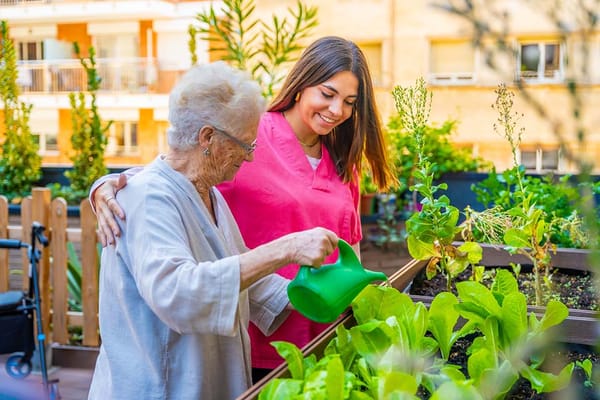 Resident and staff member gardening together