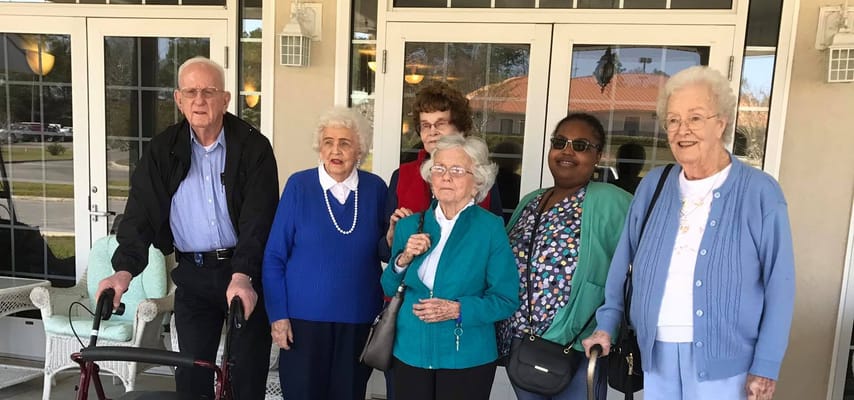 Residents posing together outside the facility