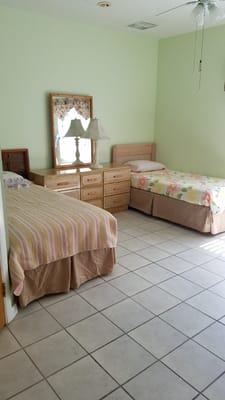 A cozy resident room with two beds and soft decor