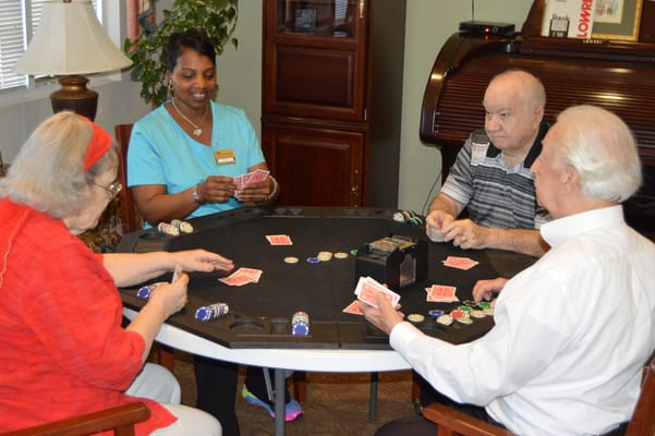 Residents enjoying a card game with staff member