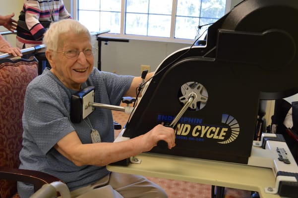 Senior resident exercising on a stationary bike