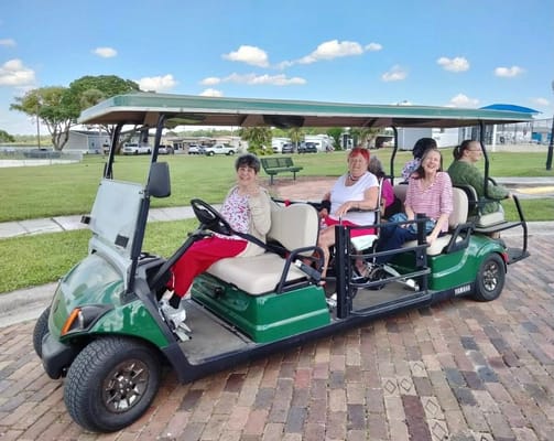 Residents enjoying a ride in a facility golf cart