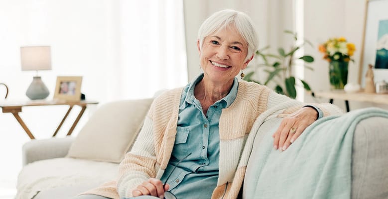 Smiling senior woman sitting comfortably in a living room