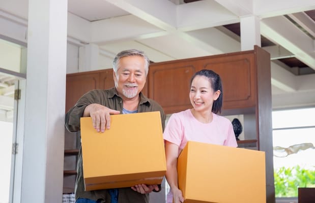 Residents and staff carrying boxes in a common area