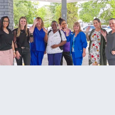 Staff members waving outside the facility