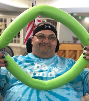 Resident enjoying an activity with a pool noodle