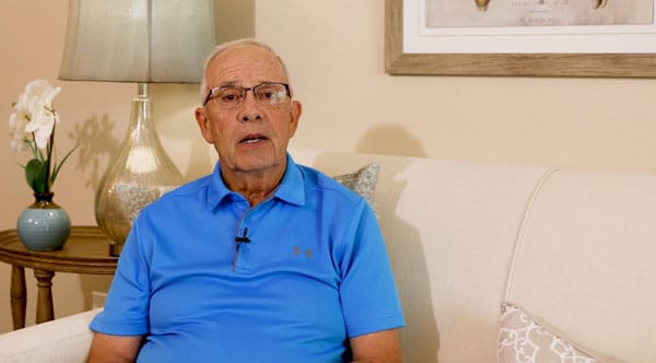 A senior man sitting on a couch in a well-lit room