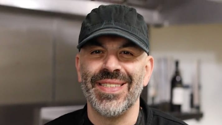 Chef smiling in a kitchen setting