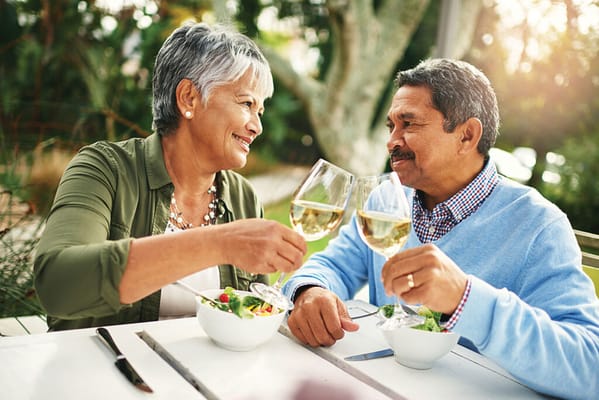 Couple toasting with glasses in a garden setting