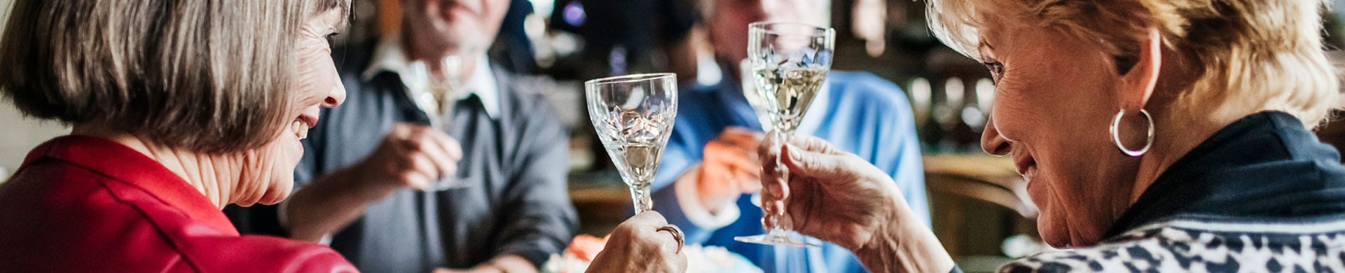 Residents celebrating with glasses raised in a vibrant activity area
