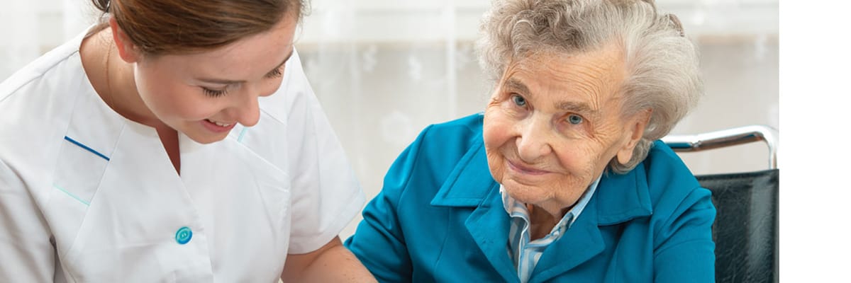 Caregiver assisting an elderly resident in a facility