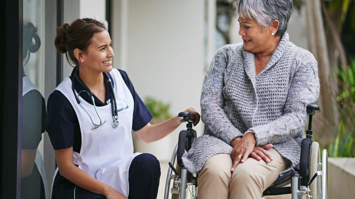 A caregiver talking with a resident in a wheelchair