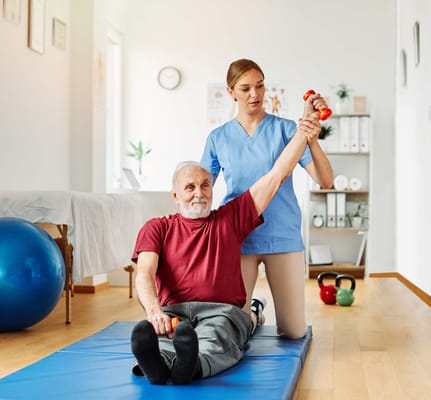 A resident exercising with a staff member in a therapy room