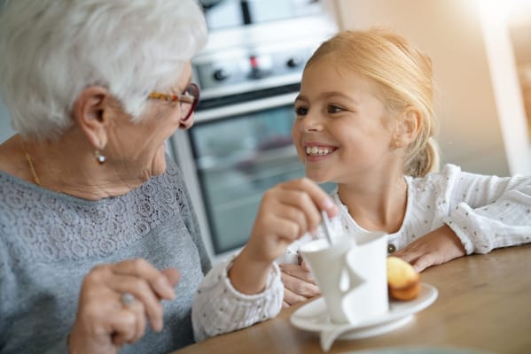 Grandmother enjoying tea with a young girl