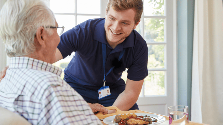 Staff member serving food to a resident