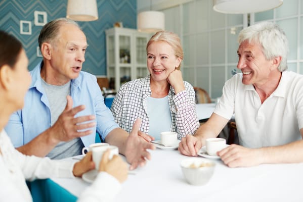 Residents enjoying conversation over coffee in a dining area