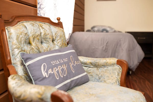 Cozy chair with decorative pillow in a resident's room